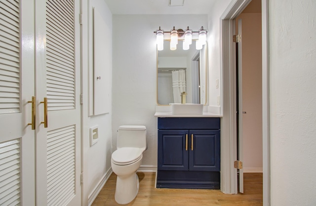 bathroom featuring vanity, wood-type flooring, and toilet