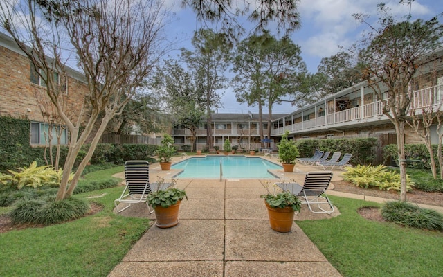 view of pool with a patio area and a yard