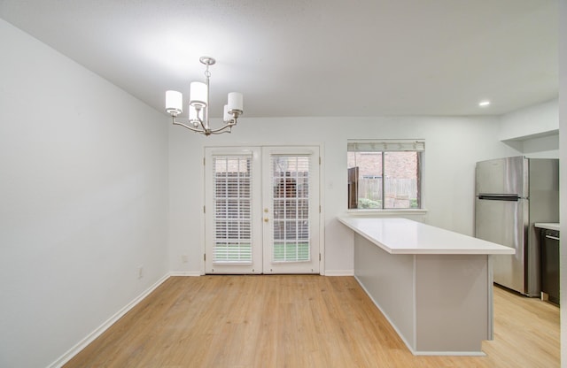 unfurnished dining area featuring light wood-type flooring and an inviting chandelier