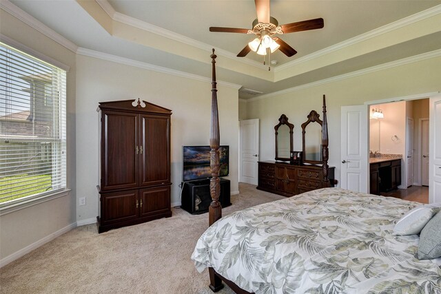 bedroom with ceiling fan, a raised ceiling, light colored carpet, and connected bathroom