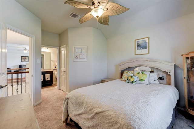 bedroom featuring ceiling fan, light colored carpet, lofted ceiling, and connected bathroom