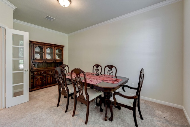 carpeted dining area with ornamental molding