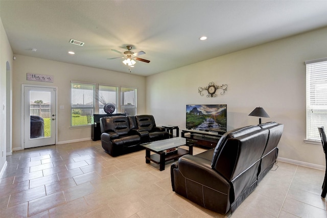 tiled living room with a wealth of natural light and ceiling fan