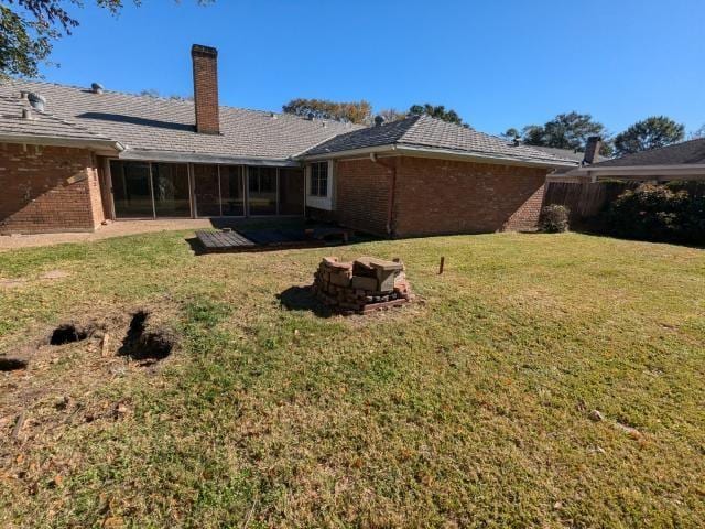 back of property featuring a lawn and a sunroom