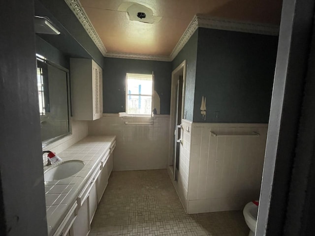 bathroom featuring crown molding, vanity, and tile walls