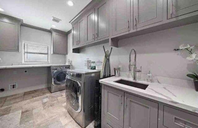 laundry area featuring cabinets, sink, and washing machine and clothes dryer