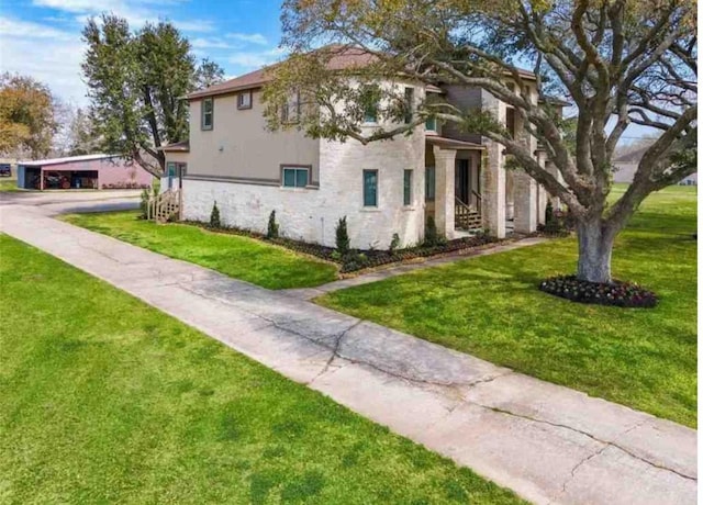 view of property exterior featuring stone siding, a lawn, and stucco siding