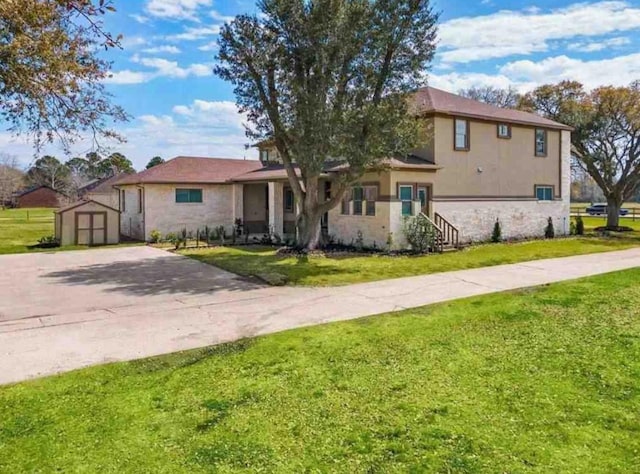 view of front of house featuring a front yard and a storage unit