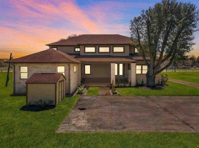 view of front of house with a lawn and a storage unit