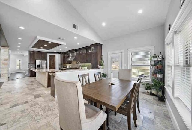 dining space featuring high vaulted ceiling