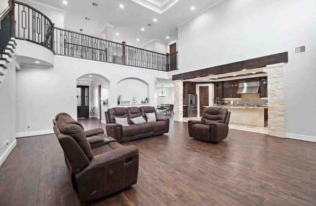 living room featuring a towering ceiling and dark hardwood / wood-style floors