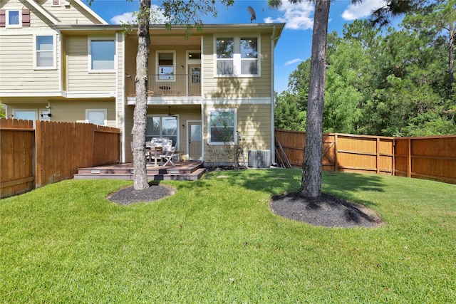 back of house featuring a lawn, a deck, central air condition unit, and a balcony