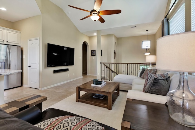 tiled living room featuring ceiling fan and high vaulted ceiling