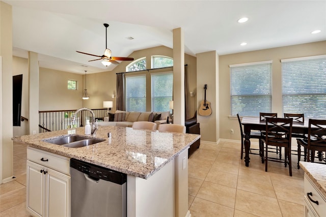 kitchen with lofted ceiling, a kitchen island with sink, sink, stainless steel dishwasher, and white cabinetry