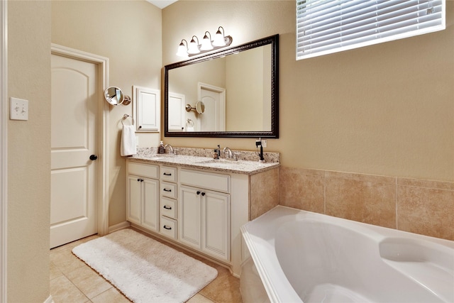 bathroom with tile patterned flooring, vanity, and a bath