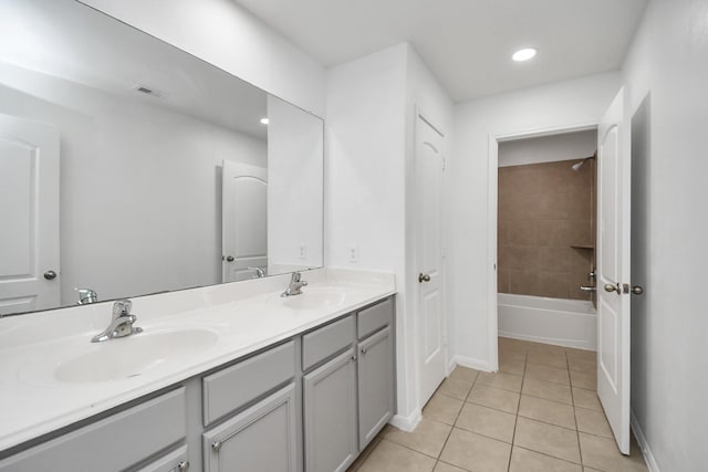 bathroom featuring tile patterned flooring, vanity, and tiled shower / bath