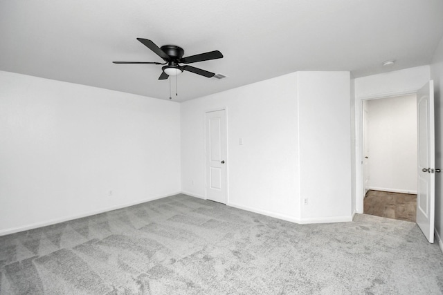 carpeted spare room featuring ceiling fan