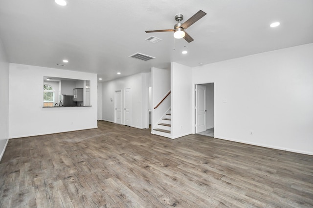 unfurnished living room with hardwood / wood-style flooring and ceiling fan