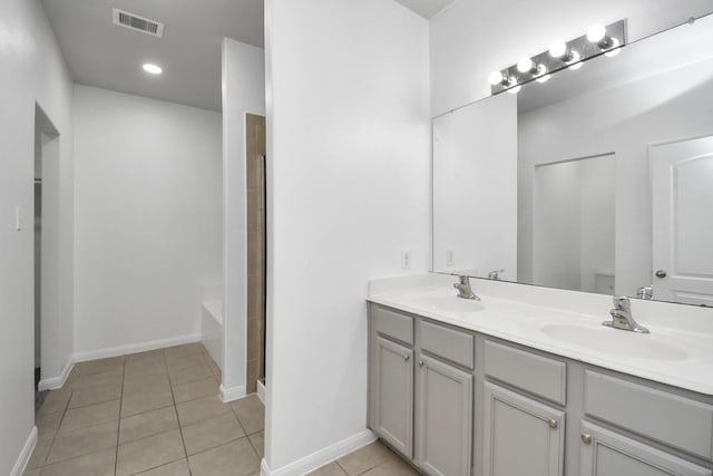 bathroom with tile patterned flooring, a washtub, and vanity