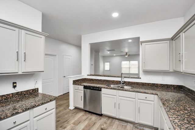 kitchen featuring white cabinets, sink, stainless steel dishwasher, ceiling fan, and dark stone countertops