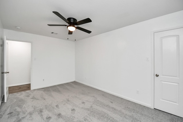 carpeted spare room with ceiling fan