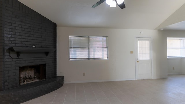 unfurnished living room with a fireplace, light tile patterned floors, vaulted ceiling, and ceiling fan