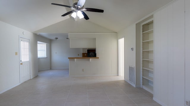 unfurnished living room with built in shelves, ceiling fan, light tile patterned floors, and lofted ceiling