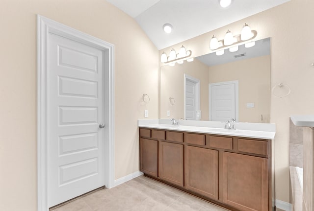 bathroom with tile patterned floors, vanity, and vaulted ceiling