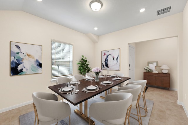 dining space with light tile patterned flooring and vaulted ceiling