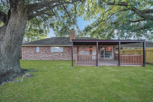 rear view of house with a lawn and a deck