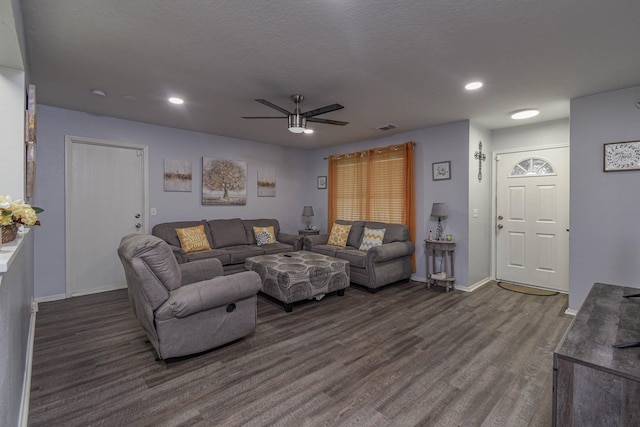 living room with ceiling fan, a textured ceiling, and dark hardwood / wood-style floors