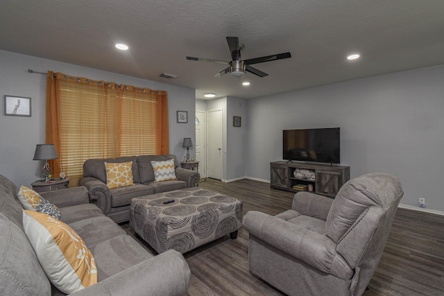 living room featuring dark wood-type flooring, a textured ceiling, and ceiling fan