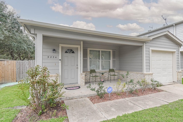 ranch-style home featuring covered porch and a garage