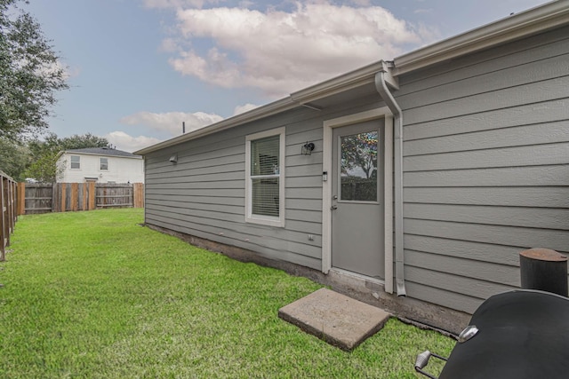 view of exterior entry featuring a yard