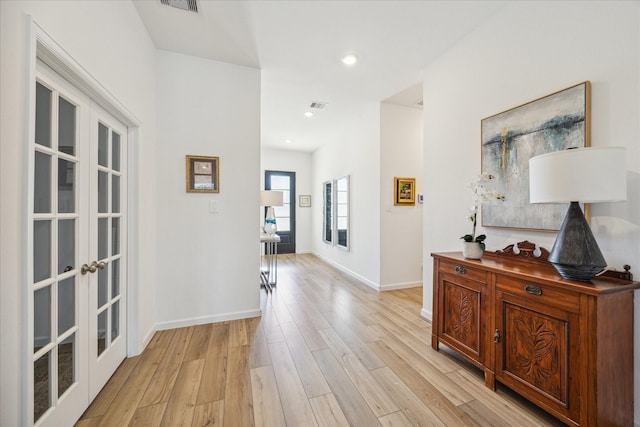 corridor with french doors and light wood-type flooring