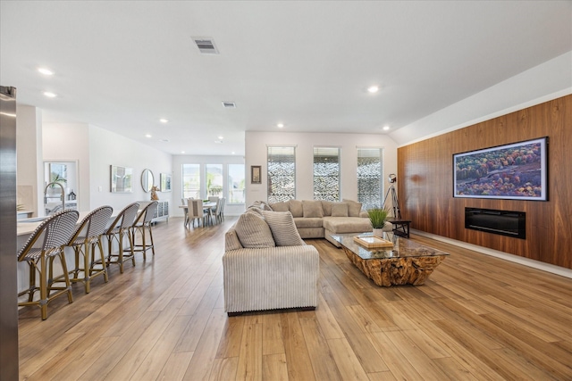 living room featuring light hardwood / wood-style floors and vaulted ceiling