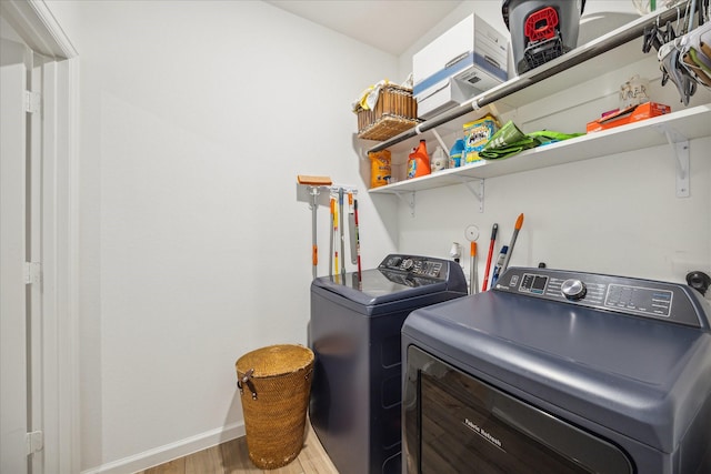 laundry room featuring wood-type flooring and separate washer and dryer