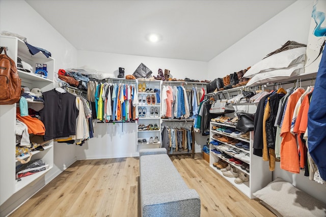 walk in closet with light hardwood / wood-style floors