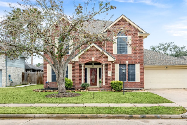 traditional home featuring a garage, driveway, fence, a front yard, and brick siding