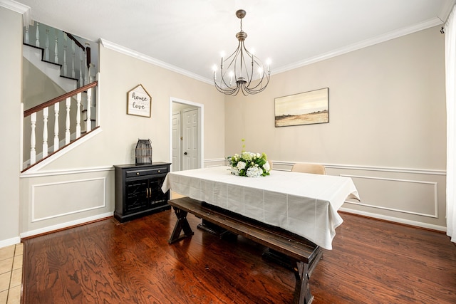 dining area featuring ornamental molding, wood-type flooring, and a notable chandelier