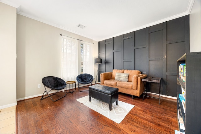 sitting room with hardwood / wood-style flooring and ornamental molding