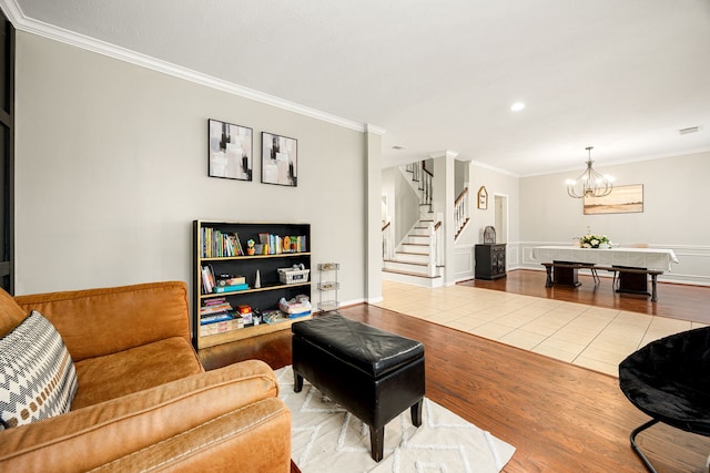 living room with hardwood / wood-style flooring, ornamental molding, and a chandelier