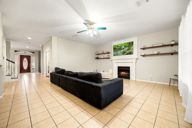 living room with a wealth of natural light, light tile patterned floors, and ceiling fan