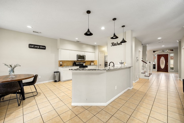 kitchen featuring stainless steel appliances, white cabinetry, light stone countertops, and light tile patterned floors