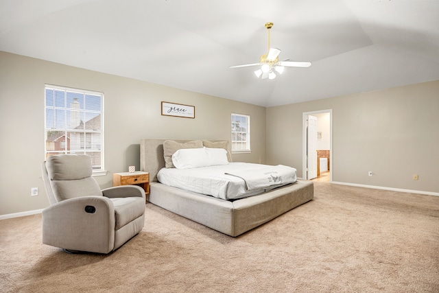 bedroom with lofted ceiling, ensuite bath, light colored carpet, and ceiling fan