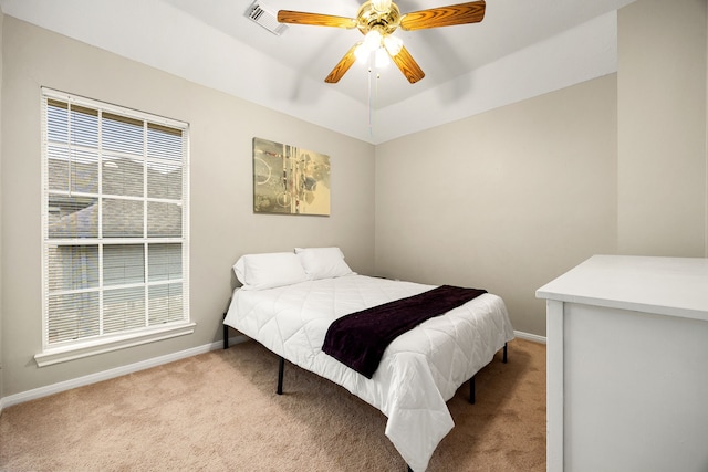 carpeted bedroom featuring ceiling fan, visible vents, and baseboards