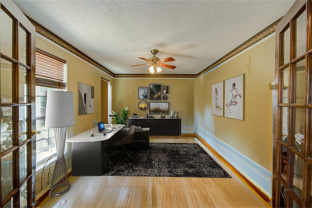 home office with a textured ceiling, a wealth of natural light, french doors, and ceiling fan