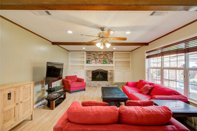 living room with hardwood / wood-style flooring, ceiling fan, a brick fireplace, a textured ceiling, and built in shelves