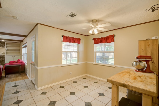 tiled dining space with built in shelves, ceiling fan, and a textured ceiling