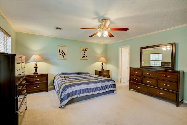 bedroom featuring crown molding, light carpet, a textured ceiling, and ceiling fan